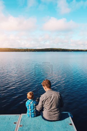 Téléchargez les photos : Son père et son fils. un père et son jeune fils à la pêche au bord du lac - en image libre de droit