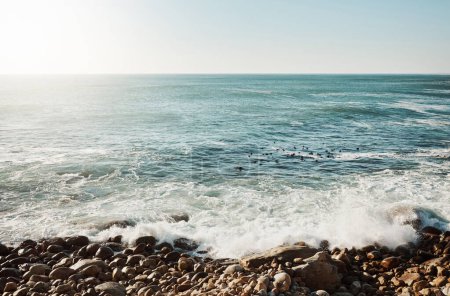Foto de ¿Cuántos secretos guarda el océano? agua chocando contra algunas rocas en la playa - Imagen libre de derechos