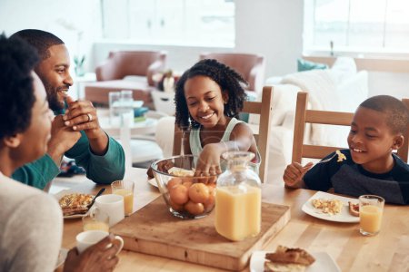 Téléchargez les photos : Commencez la journée de la meilleure façon, avec le petit déjeuner. une famille prenant le petit déjeuner ensemble à la maison - en image libre de droit