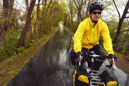 Foto de Se ha ido con el viento. un ciclista masculino disfrutando de un paseo en bicicleta en una mañana húmeda de inviernos - Imagen libre de derechos