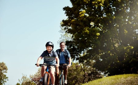 Photo for On days like these youll find them on their bikes. a young boy and his father riding together on their bicycles - Royalty Free Image