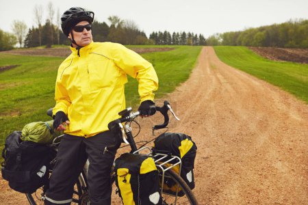 Téléchargez les photos : Cyclisme avec vue. un cycliste profitant d'une balade à vélo sur une matinée d'hivers humides - en image libre de droit