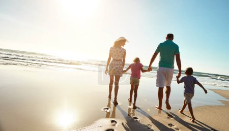 Téléchargez les photos : Dirigez-vous vers le soleil chaque fois que vous cherchez du plaisir. une famille qui passe un bon moment ensemble à la plage - en image libre de droit