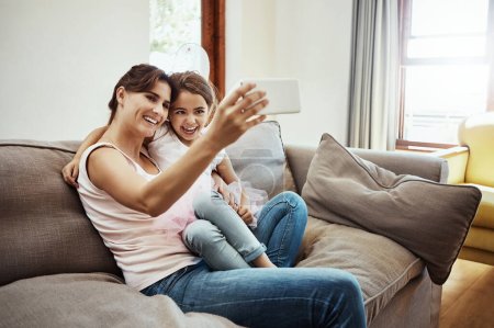 Photo for Capturing lifes sweet moments together. a mother taking a selfie with her little daughter at home - Royalty Free Image