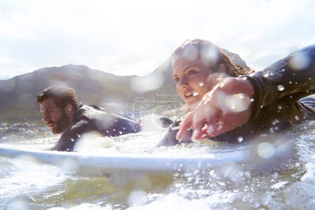 Foto de Disfrutando de una sesión épica de surf. una pareja joven surfeando juntos - Imagen libre de derechos