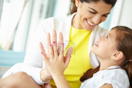 Photo for I want to grow up to be just like you. A mother and daughter putting their hands together and smiling at each other - Royalty Free Image