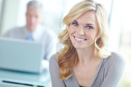 Photo for Shes passionate about her career. Cropped portrait of an attractive blonde businesswoman with a coworker in the background - Royalty Free Image