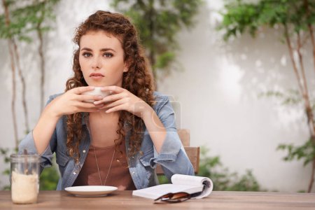 Foto de Relajarse con una taza de café fresco. una joven bebiendo café en un café - Imagen libre de derechos