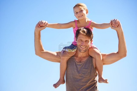 Photo for Sunshine fun time. Portrait of a handsome man giving his cute daughter a piggyback ride in the outdoors - Royalty Free Image