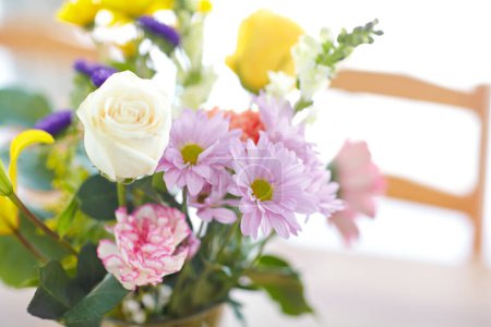Photo for Closeup of a bouquet of flowers standing on a table. Pretty flower arrangement. Colorful pink, white, purple, yellow, green flowers and roses in a bright room for mothers day, valentines day concept. - Royalty Free Image