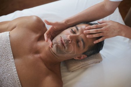 Téléchargez les photos : Pour son massage hebdomadaire. un homme mature jouissant d'un masasage relaxant - en image libre de droit