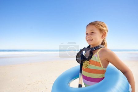 Foto de Revisando el agua. Una linda niña de pie en la playa con su tubo de snorkel, máscara y natación - Imagen libre de derechos