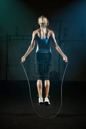 Foto de Corta la vida, ve a la cuerda. una joven saltando la cuerda en un gimnasio - Imagen libre de derechos