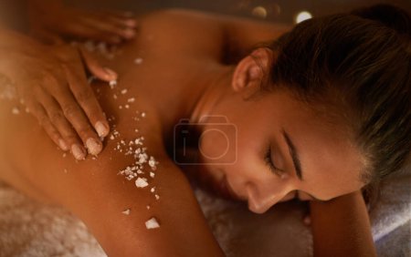 Téléchargez les photos : Everyday should be a spa day. a young woman enjoying a salt exfoliation treatment at a spa - en image libre de droit