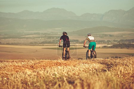 Téléchargez les photos : Monter ensemble jusqu'à la fin des temps. deux cyclistes à vélo à la campagne - en image libre de droit