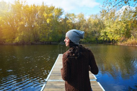 Téléchargez les photos : Journée tranquille au bord du lac. une jeune femme heureuse debout sur une jetée près d'un lac - en image libre de droit