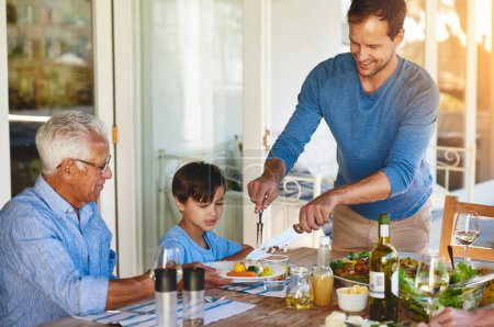 Foto de Tres generaciones en la mesa. una familia feliz disfrutando del almuerzo juntos alrededor de una mesa afuera - Imagen libre de derechos