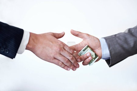 Photo for We have a deal, but keep it quiet. Cropped studio shot of money passing between two businessmens hands - Royalty Free Image