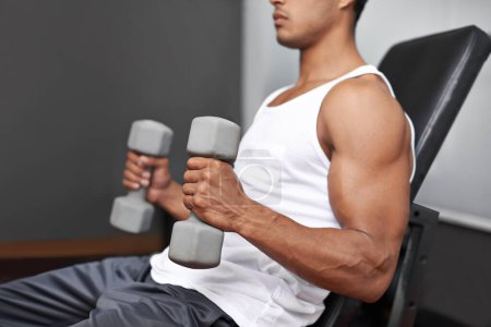 Photo for Building bulging biceps. Side view of a muscular man lifting dumbbells - Royalty Free Image