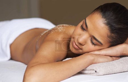Foto de Cuidado de la piel de todo el cuerpo. una joven a punto de tener un masaje en la espalda exfoliante en un spa - Imagen libre de derechos