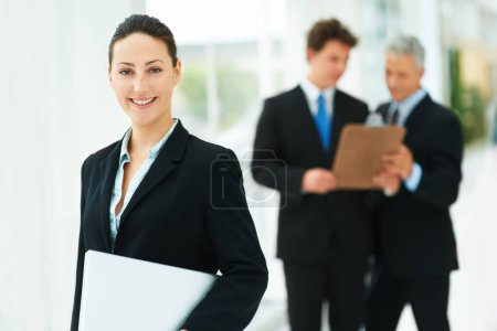 Photo for Shes a confident business leader. Portrait of a businesswoman with colleagues standing in the background - Royalty Free Image