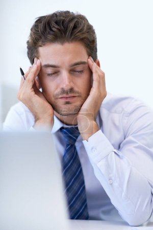 Photo for This just gives me one BIG headache. a stressed businessman holding his hands to his head - Royalty Free Image