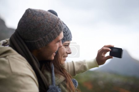 Téléchargez les photos : Je saisis le moment. Un jeune couple prenant une photo en randonnée dans les montagnes - en image libre de droit