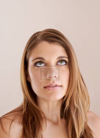 Foto de Me gusta lo que veo. Captura de estudio de una joven atractiva mirando hacia arriba en el copyspace - Imagen libre de derechos