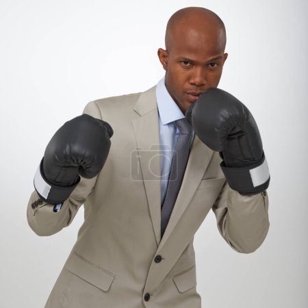 Téléchargez les photos : Prêt pour un combat d'entreprise. Portrait d'un bel homme d'affaires africain portant des gants de boxe - en image libre de droit
