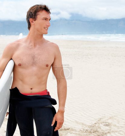 Photo for Surfing is a way of life. A young male surfer getting ready to go for a surf on a hot summers day - Royalty Free Image