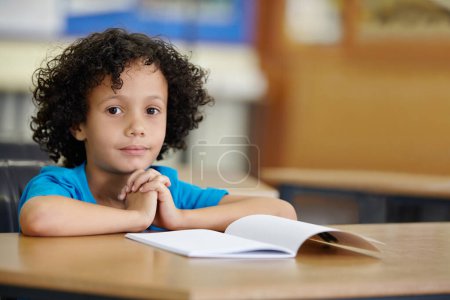 Foto de A quien le gusta una prueba. Un niño pequeño sentado en su escritorio en la escuela con copyspace - Imagen libre de derechos