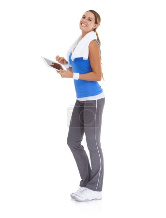 Photo for Tracking her progress with a handy app. Young woman in sportswear using a tablet while isolated on white - Royalty Free Image