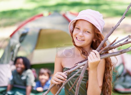 Foto de Vamos a hacer la hoguera perfecta. una joven sosteniendo ramitas frente a su campamento - Imagen libre de derechos