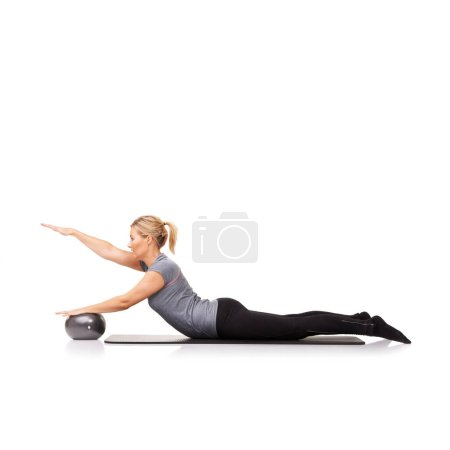 Foto de Una gran variedad de ejercicios. Una mujer joven que usa una pelota de ejercicio mientras está acostada - aislada - Imagen libre de derechos