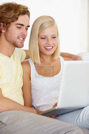 Photo for Connected from the comfort of home. A happy young couple browsing the internet together from the comfort of their couch - Royalty Free Image