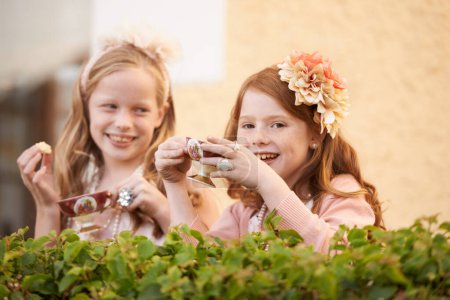 Téléchargez les photos : Faire un goûter imaginaire. Deux jeunes filles faisant une partie de thé dans le jardin - en image libre de droit