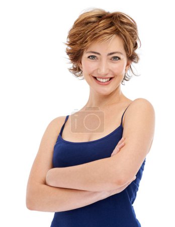 Téléchargez les photos : Satisfait de la vie. Une femme souriante debout les bras croisés alors qu'elle était isolée sur du blanc - en image libre de droit