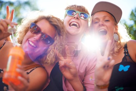 Photo for Having a great time. Three happy young women smiling at the camera and showing peace signs - Royalty Free Image