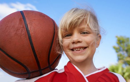 Foto de Feliz jugador de baloncesto. Una linda niña sosteniendo una pelota de baloncesto y sonriendo a la cámara - Imagen libre de derechos