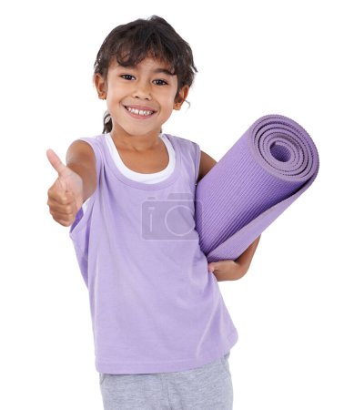Téléchargez les photos : Elle veut être prof de yoga quand elle sera grande. Une adorable petite fille avec un tapis de yoga montrant l'approbation - en image libre de droit