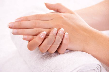 Apoyando sus manos en una toalla suave. manos de una mujer descansando sobre una toalla