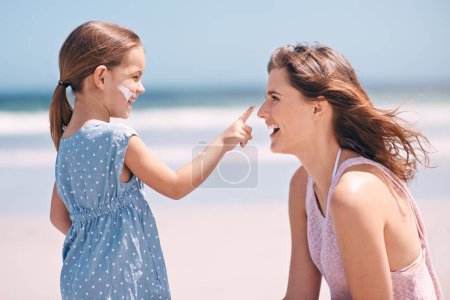 Photo for Your turn now mommy. a little girl applying suntan lotion to her mothers face at the beach - Royalty Free Image