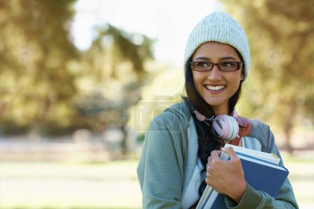 Photo for On the way to class. a young college student carrying her school books - Royalty Free Image
