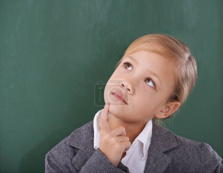 Foto de Pensando en su trabajo escolar. Una joven colegiala mirando pensativa delante del invernadero - Imagen libre de derechos