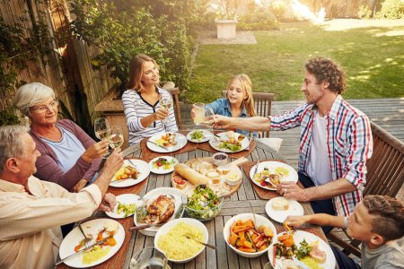 Photo for Sunday lunch is the best part of the week. a family eating lunch together outdoors - Royalty Free Image