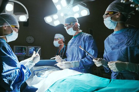 Téléchargez les photos : Des chirurgiens de confiance. chirurgiens dans une salle d'opération - en image libre de droit