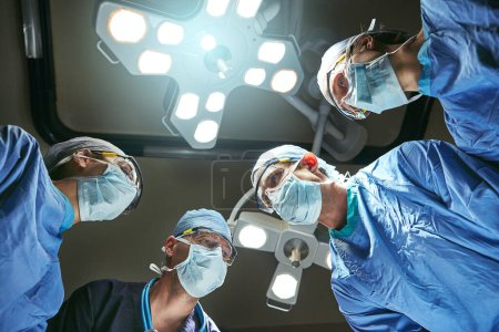 Photo for Teamwork is essential for a successful surgery. Low angle shot of surgeons in an operating room - Royalty Free Image