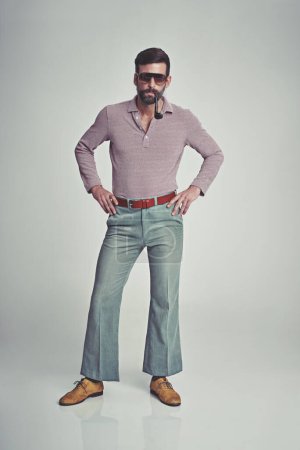 Foto de Respeta mi autoridad. Captura de estudio de un hombre guapo posando mientras usa ropa de estilo retro de los años 70. - Imagen libre de derechos