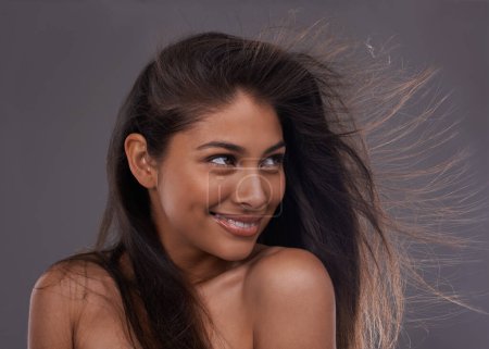 Foto de Se siente brillante y ventosa. una atractiva joven con el pelo barrido por el viento en el estudio - Imagen libre de derechos