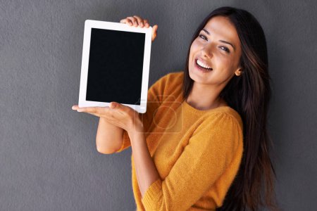 Photo for My life-saver. Portrait of an attractive young woman holding up a digital tablet with a blank screen - Royalty Free Image